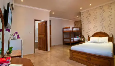 a bedroom with a bed and a crib at Green Garden Hotel in Kuta