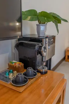 a coffee maker sitting on top of a wooden table at Rama Garden Hotel Bali in Legian