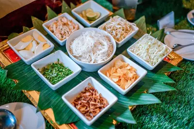 a table topped with white bowls of food on a table at Rama Garden Hotel Bali in Legian