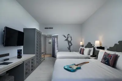 a hotel room with two beds and a flat screen tv at Hard Rock Hotel Bali in Kuta