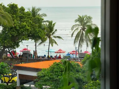 a view of a beach with palm trees and umbrellas at Mercure Kuta Bali in Kuta