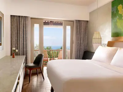 a hotel room with a bed and a balcony at Mercure Kuta Bali in Kuta