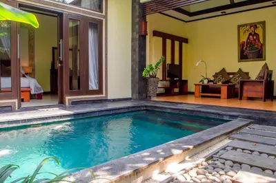 a swimming pool in front of a room with a bed at The Bali Dream Villa Seminyak in Seminyak