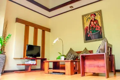 a living room with a tv and a table at The Bali Dream Villa Seminyak in Seminyak