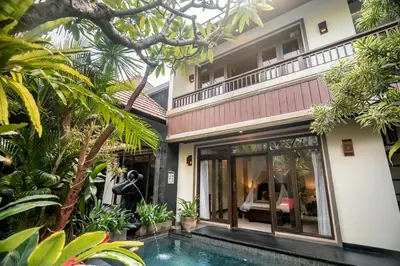 a villa with a swimming pool in front of a house at The Bali Dream Villa Seminyak in Seminyak
