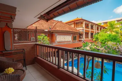 a balcony of a house with a swimming pool at Wina Holiday Villa Kuta Bali in Kuta