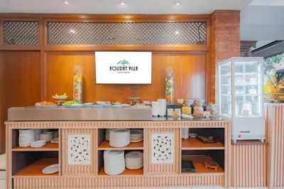 a restaurant with a counter with plates on it at Wina Holiday Villa Kuta Bali in Kuta