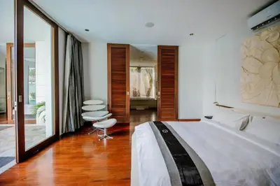 a bedroom with a large bed and two chairs at C151 Smart Villas at Seminyak in Seminyak