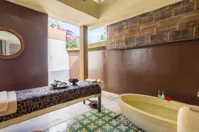 a bathroom with a bath tub and a sink at Visakha Sanur by Puri Signatures in Sanur