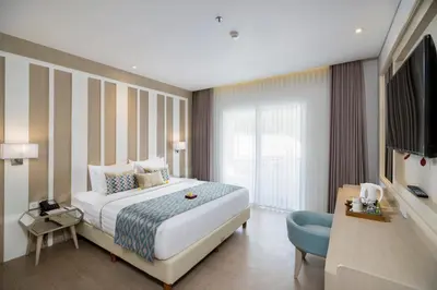 a hotel room with a bed and a television at Grand Mirage Resort & Thalasso Bali in Nusa Dua