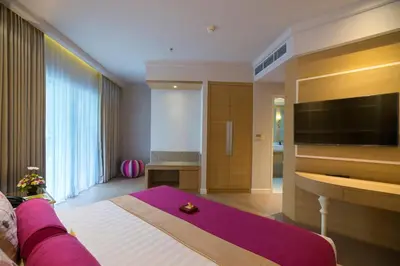 a hotel room with a bed and a tv at Grand Mirage Resort & Thalasso Bali in Nusa Dua