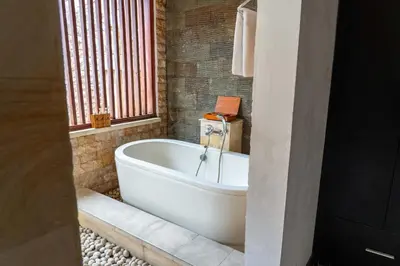 a bath tub in a bathroom with a window at Bali Prime Villas Seminyak by Kanaya Hospitality in Seminyak
