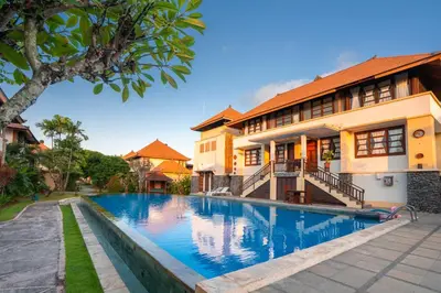 a house with a swimming pool in front of a building at Desamuda Village by Pertama Management in Seminyak