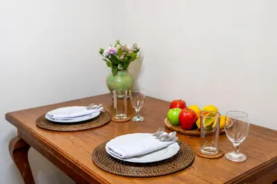 a table with plates and glasses and fruit on it at Desamuda Village by Pertama Management in Seminyak