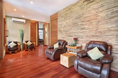 a living room with leather furniture and a brick wall at The Elysian Boutique Villa Hotel in Seminyak