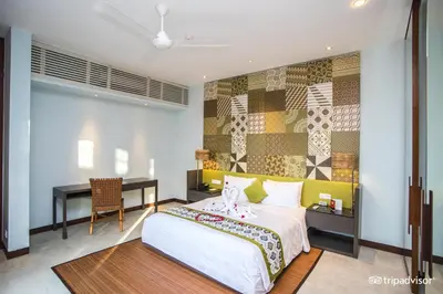 a bedroom with a bed and a desk and a table at The Elysian Boutique Villa Hotel in Seminyak
