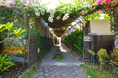 a garden with a pergola with flowers on it at Sayang Residence 2 in Denpasar