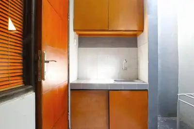 a kitchen with wooden cabinets and a sink at Sayang Residence 2 in Denpasar