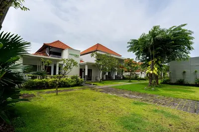 a house with a green yard and trees at Kusuma Resort Seminyak in Seminyak