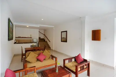 a living room with two couches and a table at Kusuma Resort Seminyak in Seminyak