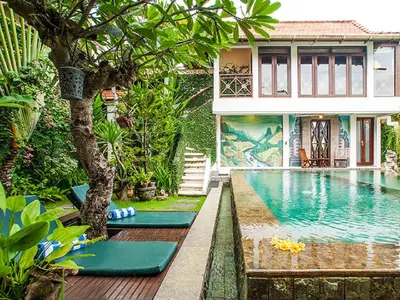 a house with a swimming pool in front of a house at Umah Watu Villas in Seminyak