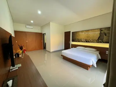 a bedroom with a bed and a painting on the wall at New Garden View Resort in Legian