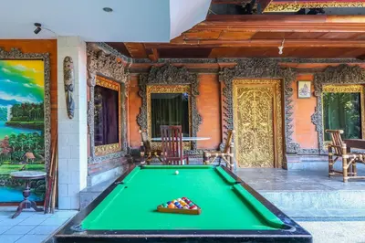 a pool table in front of a house at Capital O 1666 Grand Pudjawan Hotel Near Kuta Beach in Kuta