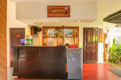 a kitchen with a counter and a refrigerator at Capital O 1666 Grand Pudjawan Hotel Near Kuta Beach in Kuta