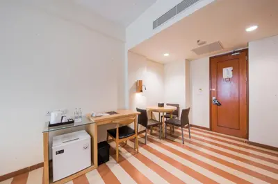 a room with a desk and a table and chairs at The ONE Legian in Legian