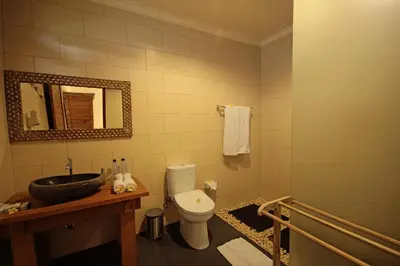 a bathroom with a toilet and a sink and a mirror at Mina Pelasa Hotel in Legian