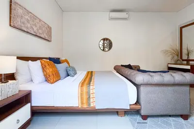 a bedroom with a bed and a chair at Villa Manis La Bora in Seminyak in Seminyak