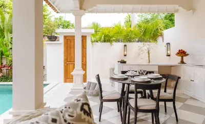 a dining room and kitchen with a table and chairs at Puri Pani in Seminyak