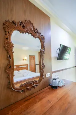 a mirror on a wall with a bed in a room at Palm Beach Hotel Bali in Kuta