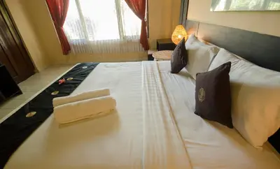 a large white bed in a hotel room at Taman Sari Cottages in Kuta