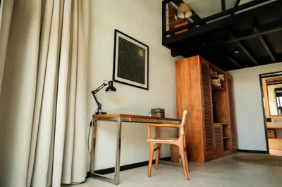 a desk with a lamp and a chair in a room at Wave House Resort Canggu in Canggu