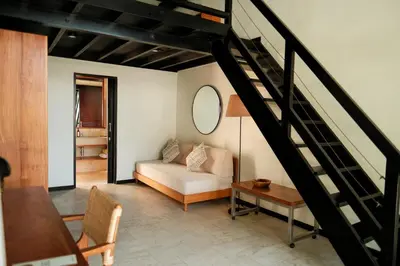 a living room with a white couch and a staircase at Wave House Resort Canggu in Canggu