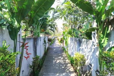 a path through a garden with trees and plants at Bali Merita Villa in Canggu