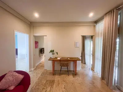 a living room with a table and a couch at Kresna By The Sea By Kresna Hospitality in Seminyak