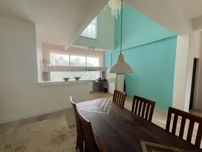 a dining room with a wooden table and chairs at Kresna By The Sea By Kresna Hospitality in Seminyak