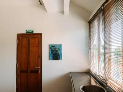a kitchen with a wooden door and a sink at Kresna By The Sea By Kresna Hospitality in Seminyak
