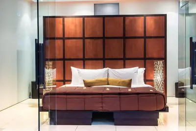 a bedroom with a bed with a large wooden headboard at Kembali Villas in Seminyak