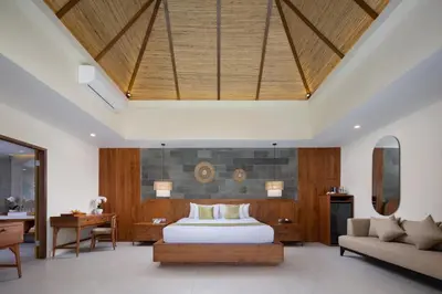 a bedroom with a bed and a desk and a couch at Tonys Villas & Resort Seminyak - Bali in Seminyak
