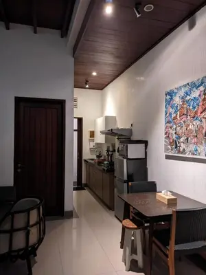 a kitchen and dining room with a table and chairs at Dim House Jimbaran in Jimbaran