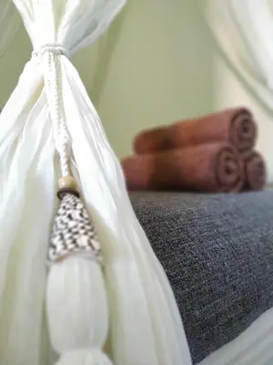 a close up of a bed with white sheets and a book at Dim House Jimbaran in Jimbaran
