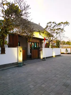 a house with a white fence and a flag in front of it at Dim House Jimbaran in Jimbaran