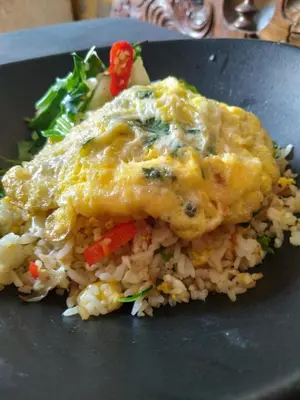 a plate of food with a piece of chicken and rice at Dim House Jimbaran in Jimbaran