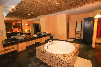a large bathroom with two sinks and a tub at Kupu Kupu Jimbaran Beach Hotel & Spa by L’Occitane in Jimbaran