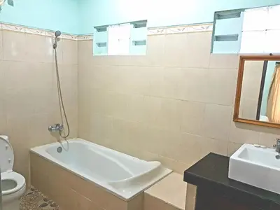 a bathroom with a tub and a toilet and a sink at Degung de brata Family villas in Legian