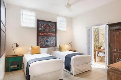 two beds in a room with white walls at Villa Bebek in Seminyak