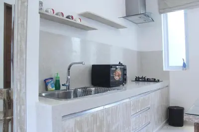 a kitchen with a sink and a microwave at Green Studio Apartment Seminyak in Seminyak